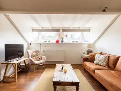 a living room with a couch and a table at De egelhut in Bergen