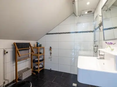 a bathroom with a sink and a shower at De egelhut in Bergen