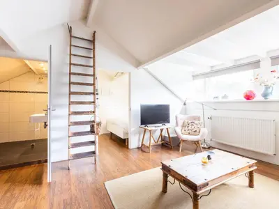 a living room with a ladder and a table at De egelhut in Bergen