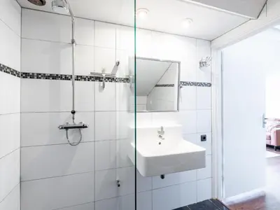 a white bathroom with a sink and a mirror at De egelhut in Bergen
