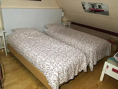 a bedroom with a bed with a comforter on it at Paul en Lettie's Bed and Breakfast in Westbroek