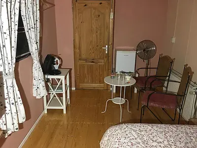 a living room with a table and chairs and a door at Paul en Lettie's Bed and Breakfast in Westbroek