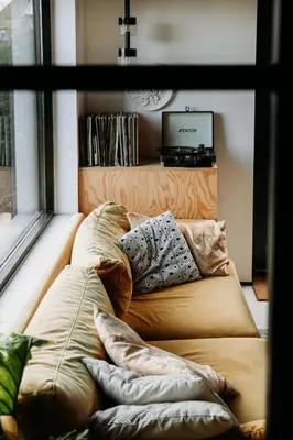a couch sitting next to a window with pillows at Sfeervol Vakantiehuis - Badkuip met weids uitzicht - Markermeer - by Familie Buitenhuys holiday houses in Oosterleek