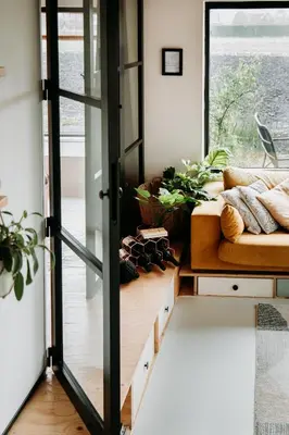 a living room with a couch and a window at Sfeervol Vakantiehuis - Badkuip met weids uitzicht - Markermeer - by Familie Buitenhuys holiday houses in Oosterleek