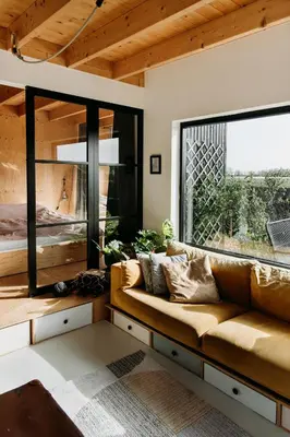 a living room with a couch and a large window at Sfeervol Vakantiehuis - Badkuip met weids uitzicht - Markermeer - by Familie Buitenhuys holiday houses in Oosterleek