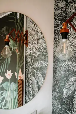 a mirror hanging on a wall next to a lamp at Sfeervol Vakantiehuis - Badkuip met weids uitzicht - Markermeer - by Familie Buitenhuys holiday houses in Oosterleek