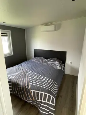 a bedroom with a bed with a striped comforter at Miva in Leiderdorp