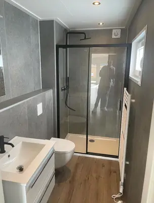 a man taking a picture of a bathroom with a shower at Miva in Leiderdorp