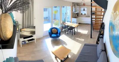 a living room with a blue chair and a table at Vakantiehuis Boulevard in Egmond aan Zee