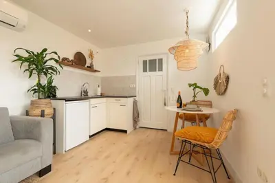 a kitchen with a couch and a table in a room at Faya Beachhouse in Noordwijk aan Zee