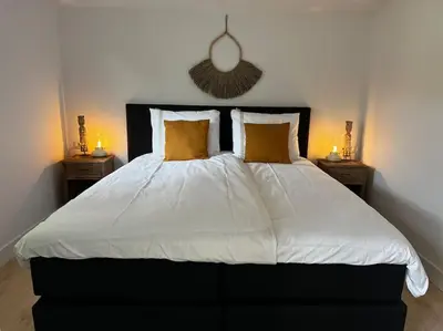 a bedroom with a large white bed with two night stands at Faya Beachhouse in Noordwijk aan Zee