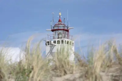 a lighthouse with a red and white at Faya Beachhouse in Noordwijk aan Zee