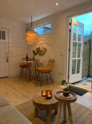 a living room with a couch and a table at Faya Beachhouse in Noordwijk aan Zee