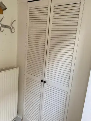 a closet door with white blinds in a room at Spes Salutis in Badhoevedorp