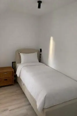 a bedroom with a white bed and a night stand at Spes Salutis in Badhoevedorp