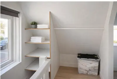 a staircase with white shelves in a room with a window at Spes Salutis in Badhoevedorp