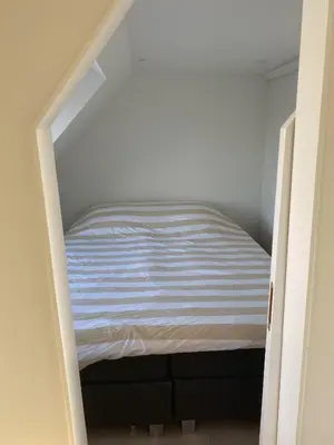 a small bedroom with a bed in a room at Spes Salutis in Badhoevedorp
