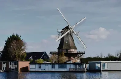 a windmill sitting in the middle of the water at Spes Salutis in Badhoevedorp