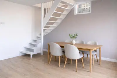 a dining room with a table and chairs and a staircase at Spes Salutis in Badhoevedorp