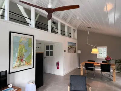 a living room with a table and chairs and a ceiling at Het Zomerhuis in Zuidbakkum
