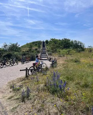 a person sitting on a bike next to a staircase at Het Zomerhuis in Zuidbakkum