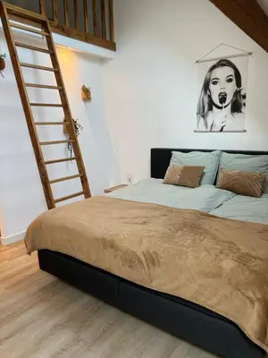 a bedroom with a large bed with a staircase at Naast 37 Overnachten in Driebergen