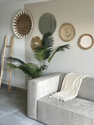 a living room with a couch and a mirror at Naast 37 Overnachten in Driebergen