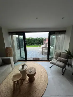 a living room with a large window and a table at Naast 37 Overnachten in Driebergen