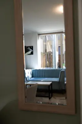 a blue couch in a living room through a mirror at Plantage Garden Apartments in Amsterdam