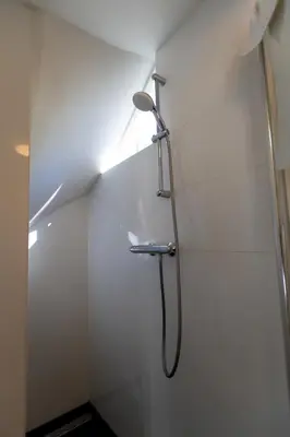 a shower with a shower head in a bathroom at Plantage Garden Apartments in Amsterdam