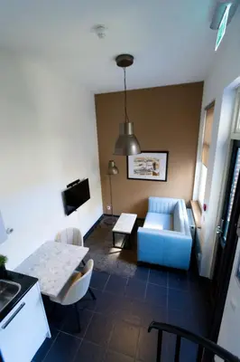 a living room with a blue couch and a table at Plantage Garden Apartments in Amsterdam