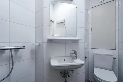 a white bathroom with a sink and a mirror at Plantage Garden Apartments in Amsterdam