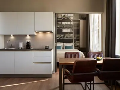 a kitchen and a bedroom with a bed and a table at YAYS Amsterdam Maritime by Numa in Amsterdam