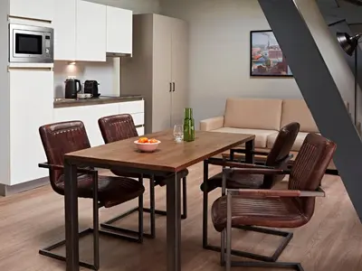 a kitchen and dining room with a wooden table and chairs at YAYS Amsterdam Maritime by Numa in Amsterdam
