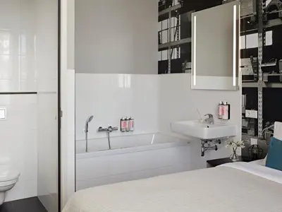 a bathroom with a bed and a tub and a sink at YAYS Amsterdam Maritime by Numa in Amsterdam