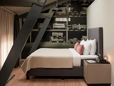 a bedroom with a large bed with pink pillows at YAYS Amsterdam Maritime by Numa in Amsterdam