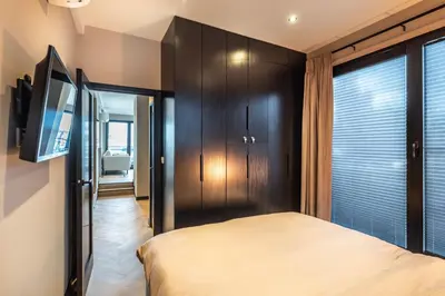 a bedroom with a bed and a large window at Luxury Watervilla Near Amsterdam And Schiphol in Aalsmeer