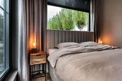 a bedroom with a bed and a large window at Luxury Watervilla Near Amsterdam And Schiphol in Aalsmeer