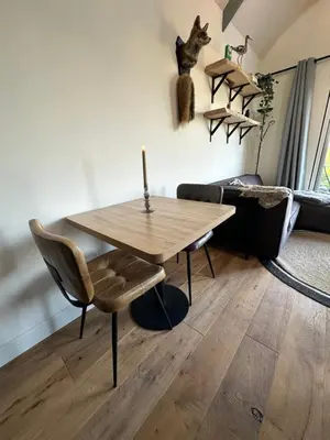 a dining room with a wooden table and a chair at 't Jisper Huisje in Jisp