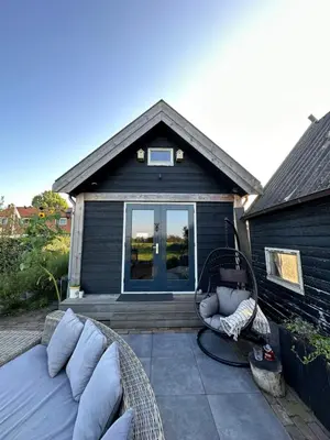 a backyard patio with a couch and a swing at 't Jisper Huisje in Jisp