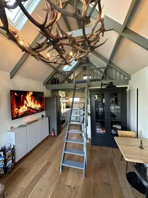 a room with a ladder and a fire in the ceiling at 't Jisper Huisje in Jisp