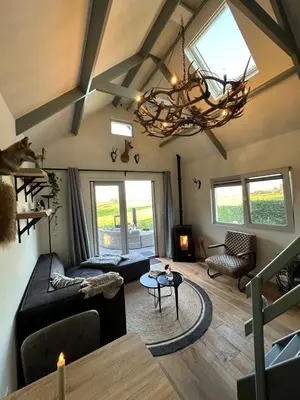 a living room with a couch and a chandelier at 't Jisper Huisje in Jisp