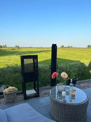 a table with a chair and a table with flowers on it at 't Jisper Huisje in Jisp