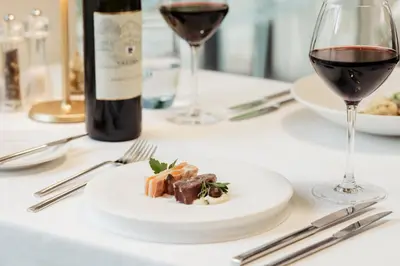 a table with a plate of food and a bottle of wine at Leerhotel Het Klooster in Amersfoort