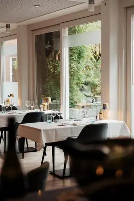 a room with tables with wine glasses and a window at Leerhotel Het Klooster in Amersfoort
