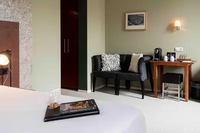 a room with a bed and a chair and a table at Leerhotel Het Klooster in Amersfoort