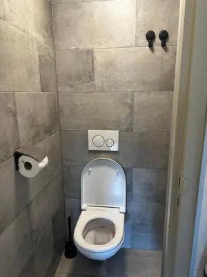 a bathroom with a toilet and a toilet paper dispenser at Garden house, Free parking in Zandvoort