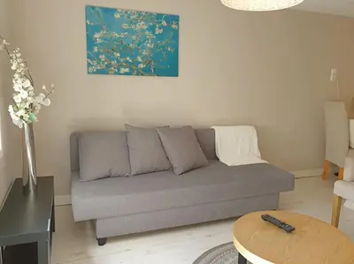 a living room with a gray couch and a table at Garden house, Free parking in Zandvoort