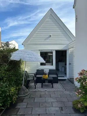 a patio with two chairs and a table with an umbrella at Garden house, Free parking in Zandvoort