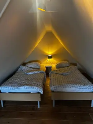 two beds in a room with a roof at Garden house, Free parking in Zandvoort